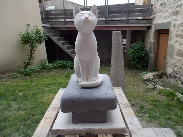 Chat Bastet en calcaire coquillé sur son coussin de basalte, de garde.